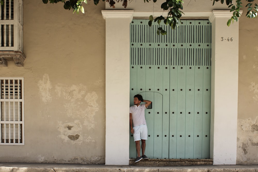 a man standing in front of a green door