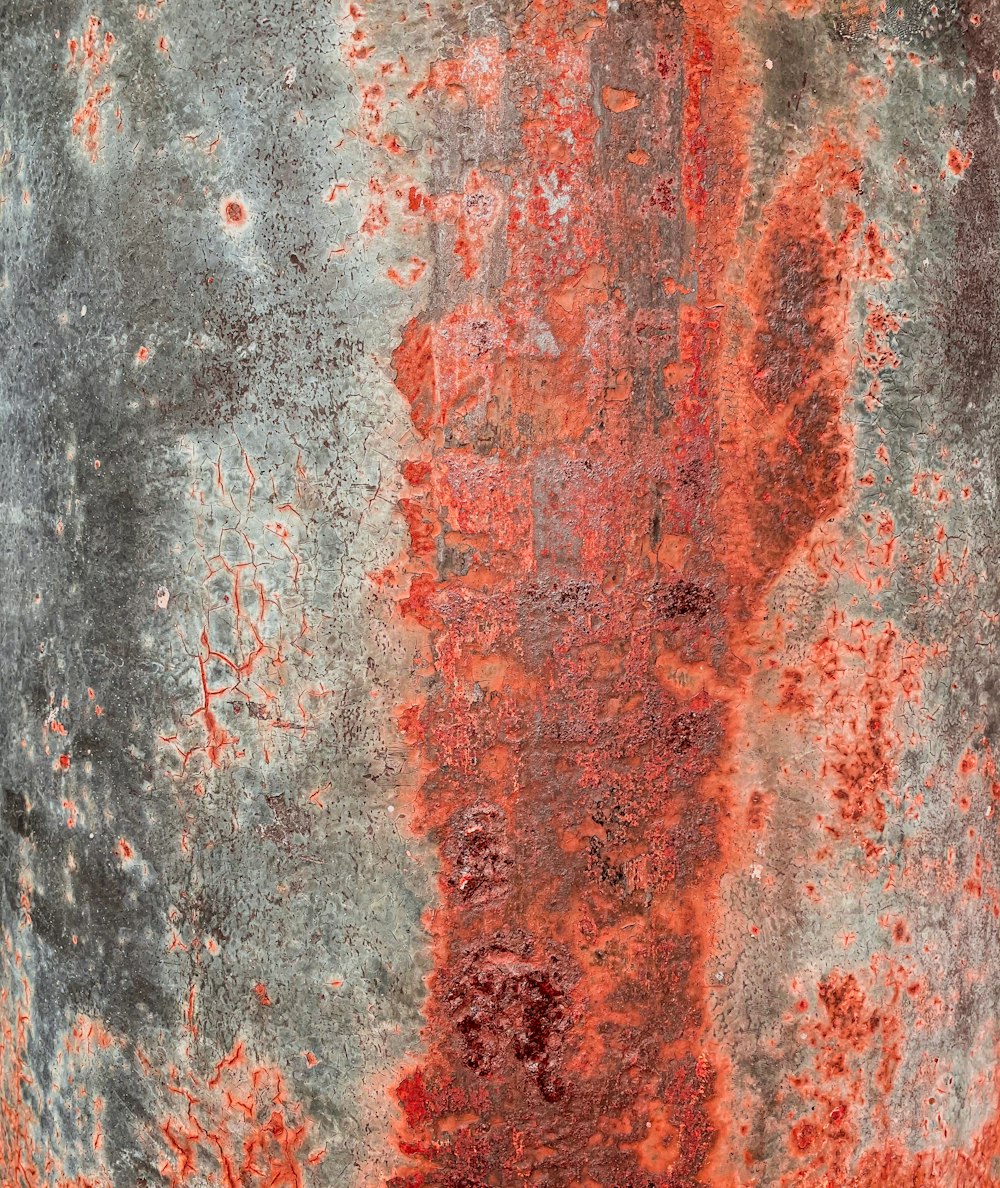 a rusted metal surface with red and grey paint