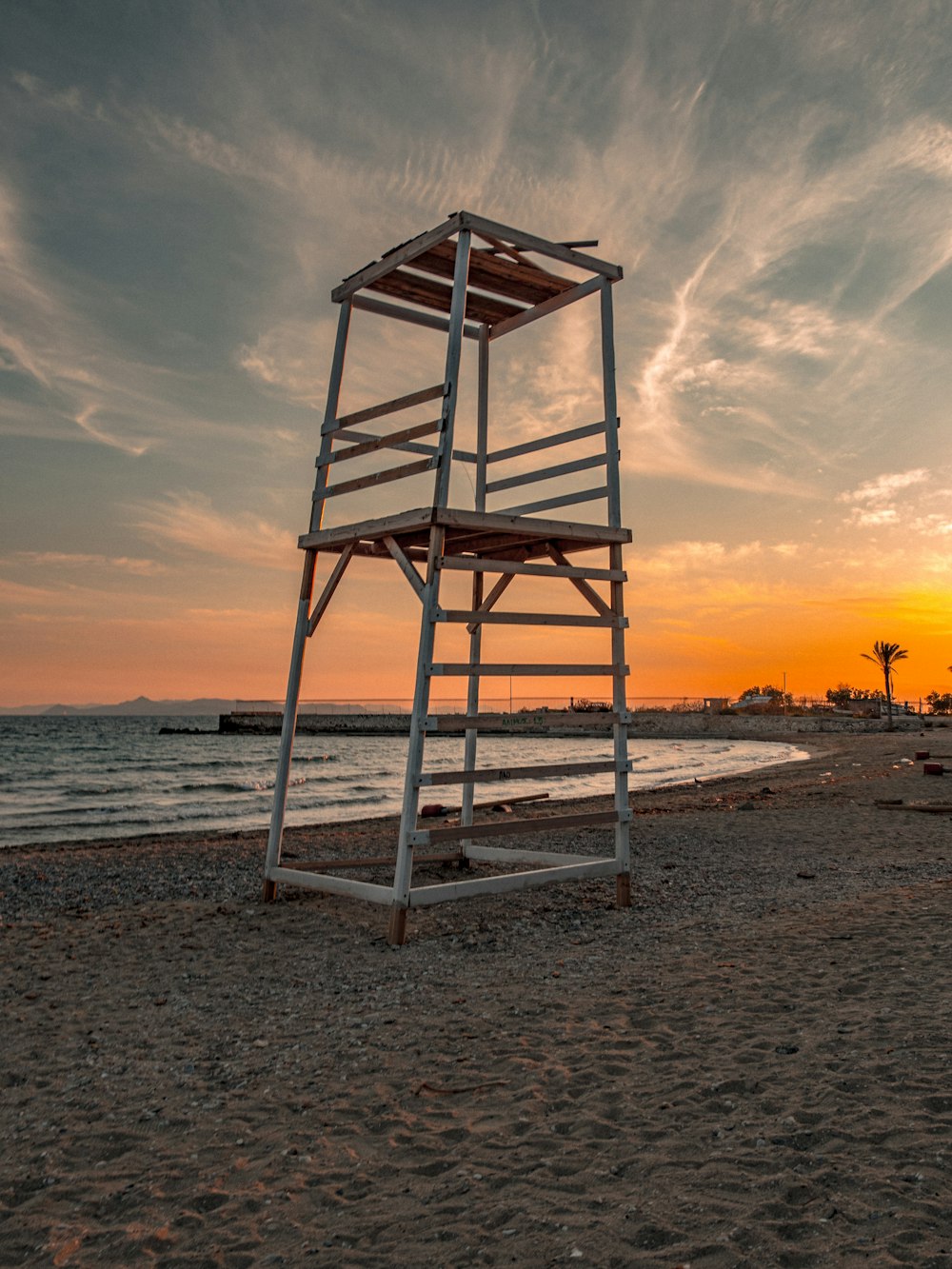 a lifeguard tower sitting on top of a sandy beach