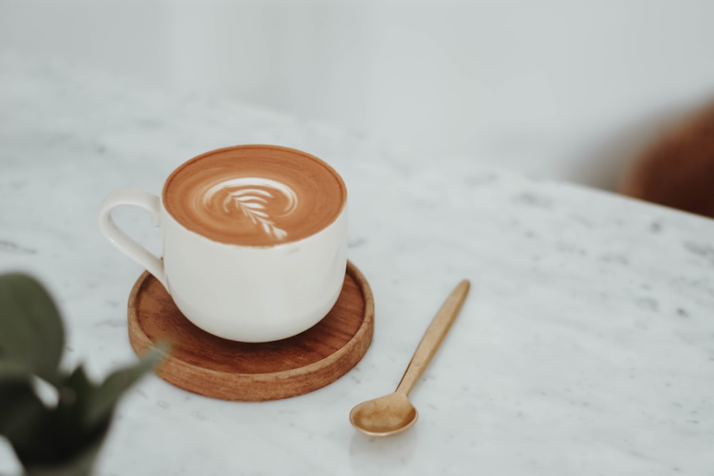 a cup of coffee on a saucer with a spoon