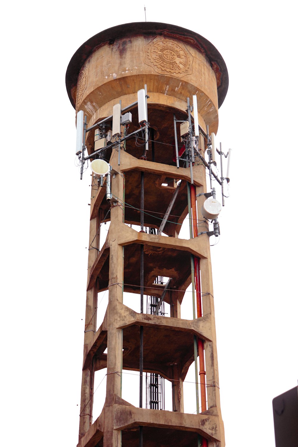 uma torre de madeira alta com um relógio de lado