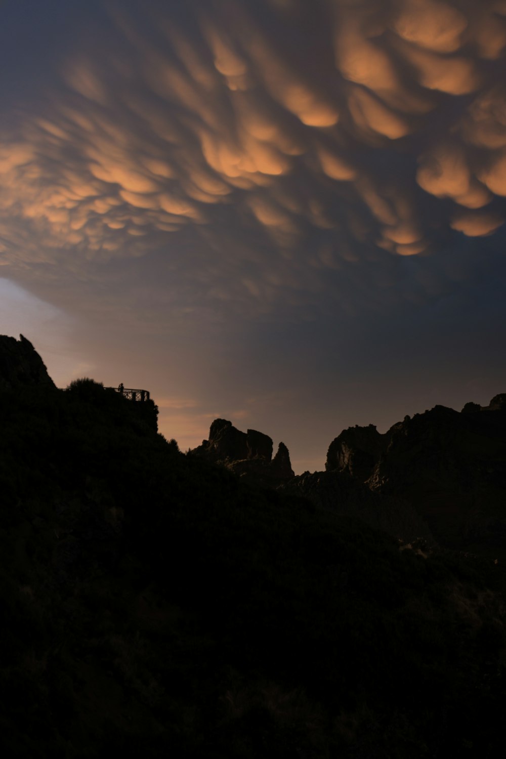 a large cloud is in the sky over a mountain