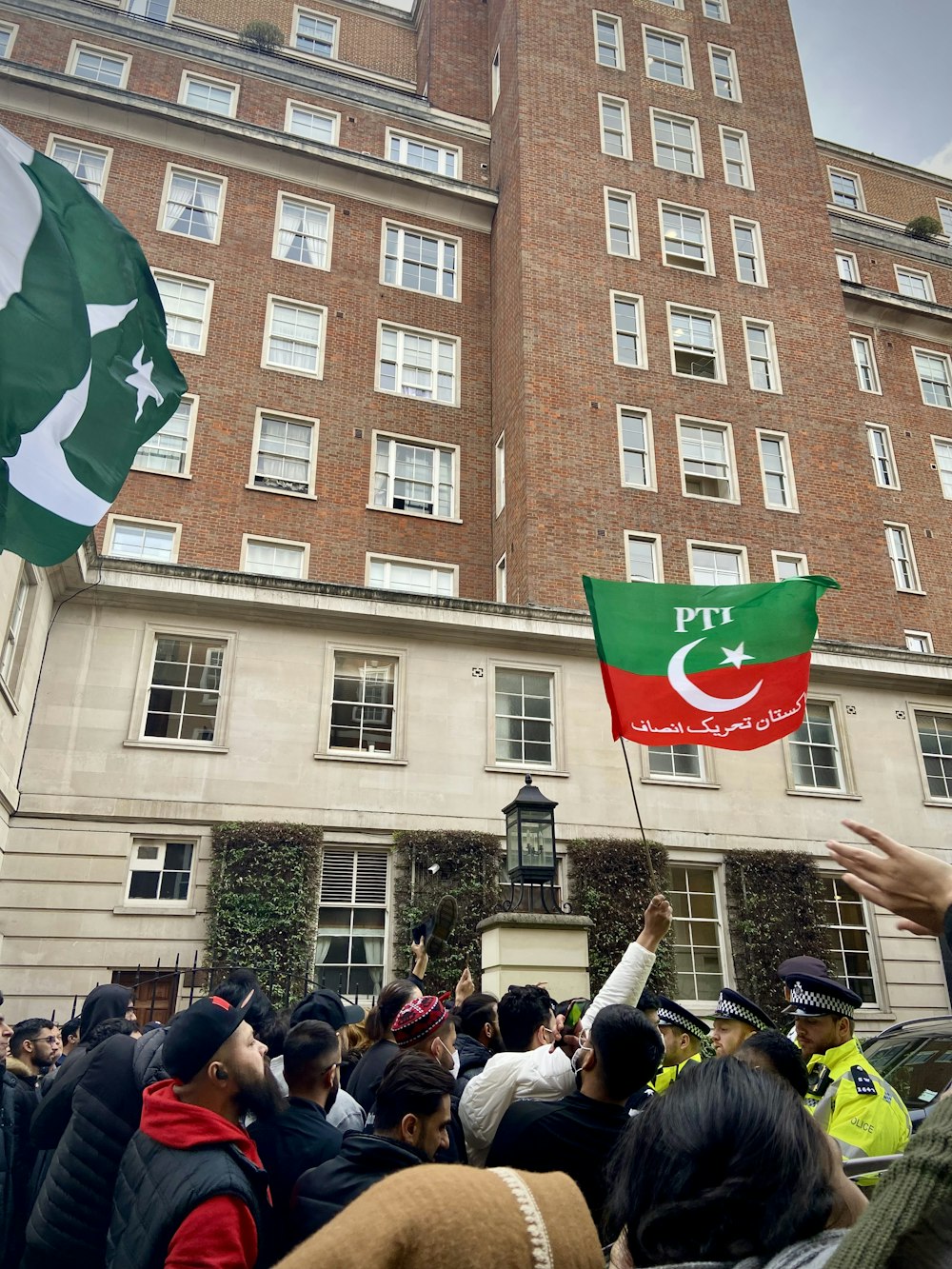 a group of people holding flags in front of a building