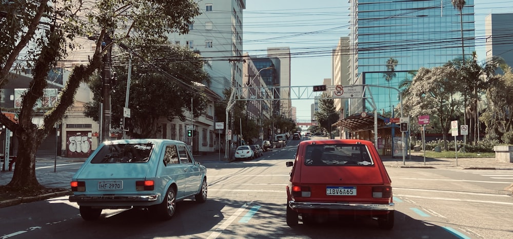 a red car driving down a street next to a blue car