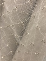 Soft lighting highlighting the intricate beadwork on a champagne-colored dress.