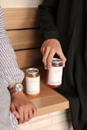 a person sitting on a bench holding a jar of jam