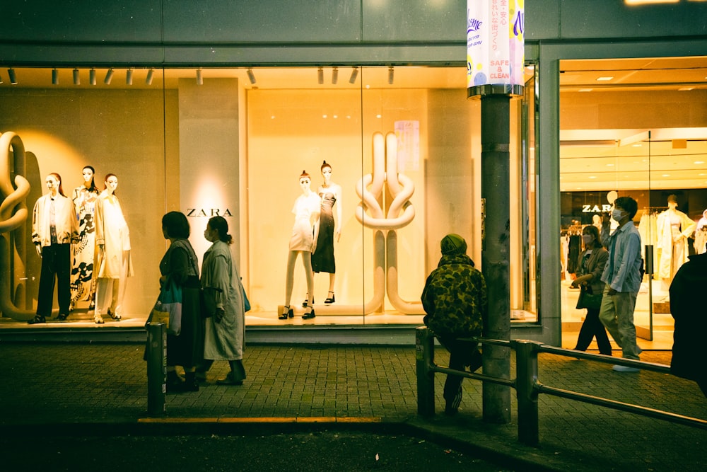 a group of people standing in front of a store window