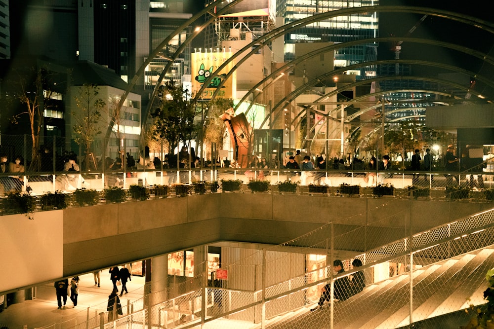 a group of people walking down a walkway at night