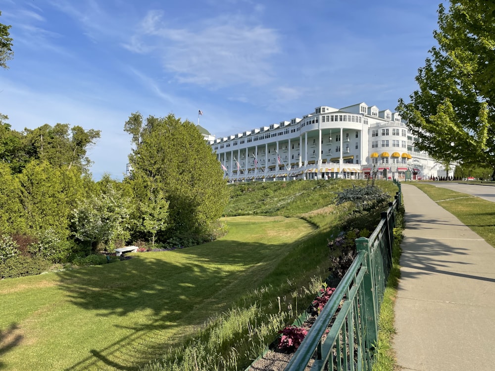 a large white building sitting on top of a lush green hillside