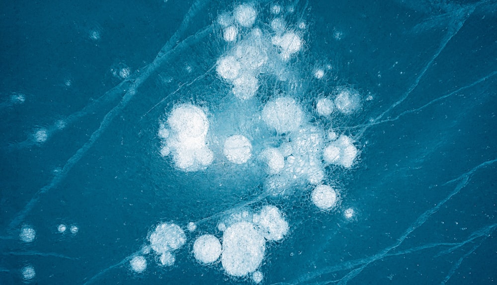 a blue background with white bubbles in the water