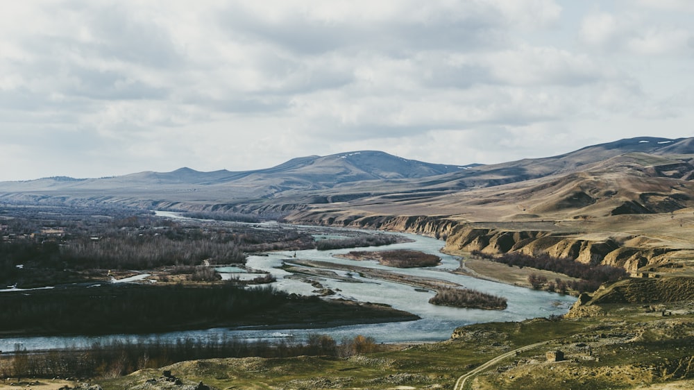 a river running through a valley surrounded by mountains