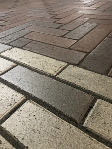 Close-up of a decorative stamped concrete walkway featuring a brick pattern.