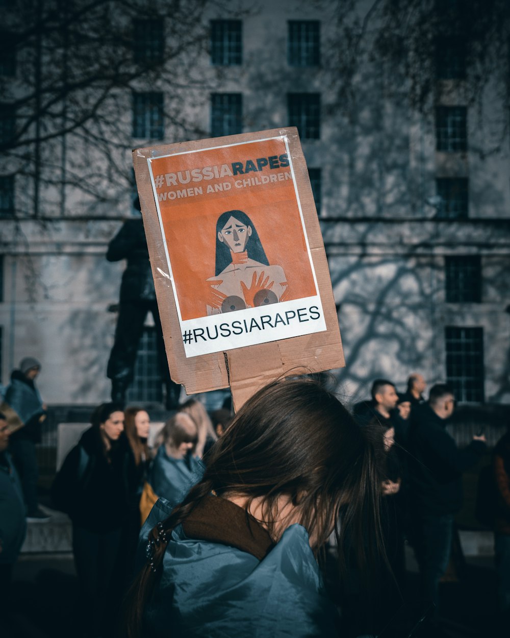 a woman holding a sign with a woman's face on it