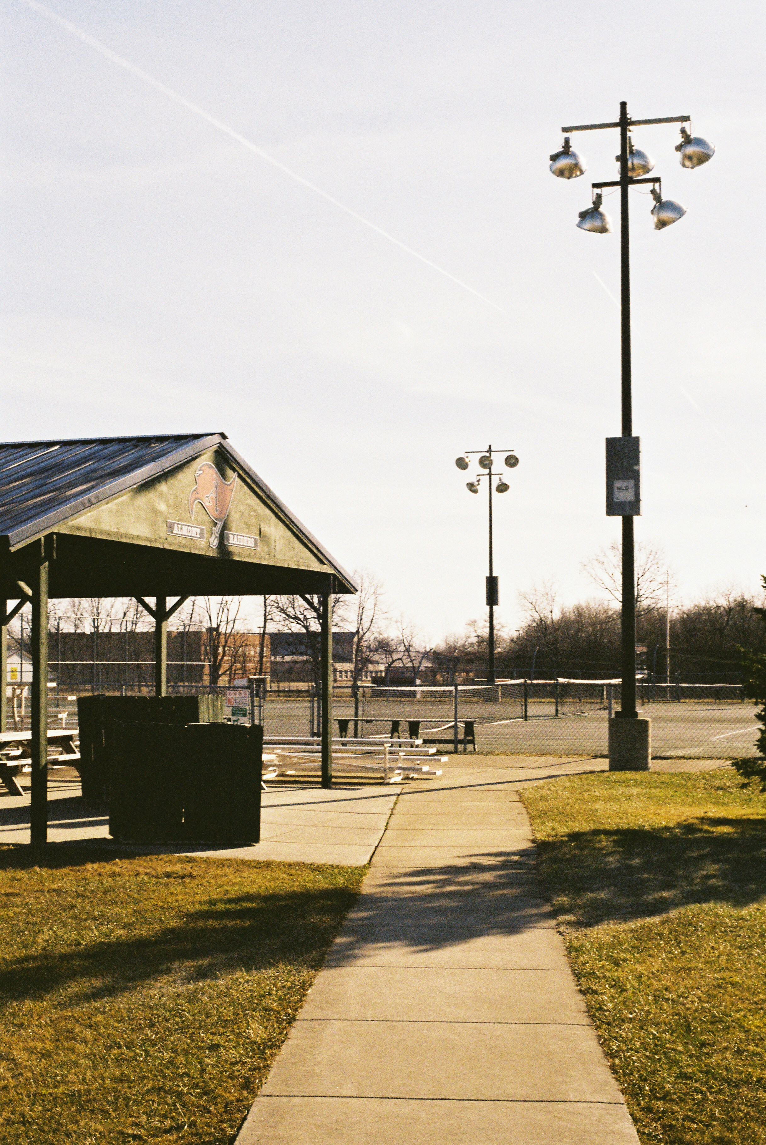 a walkway leading to a covered area with a light pole in the background
