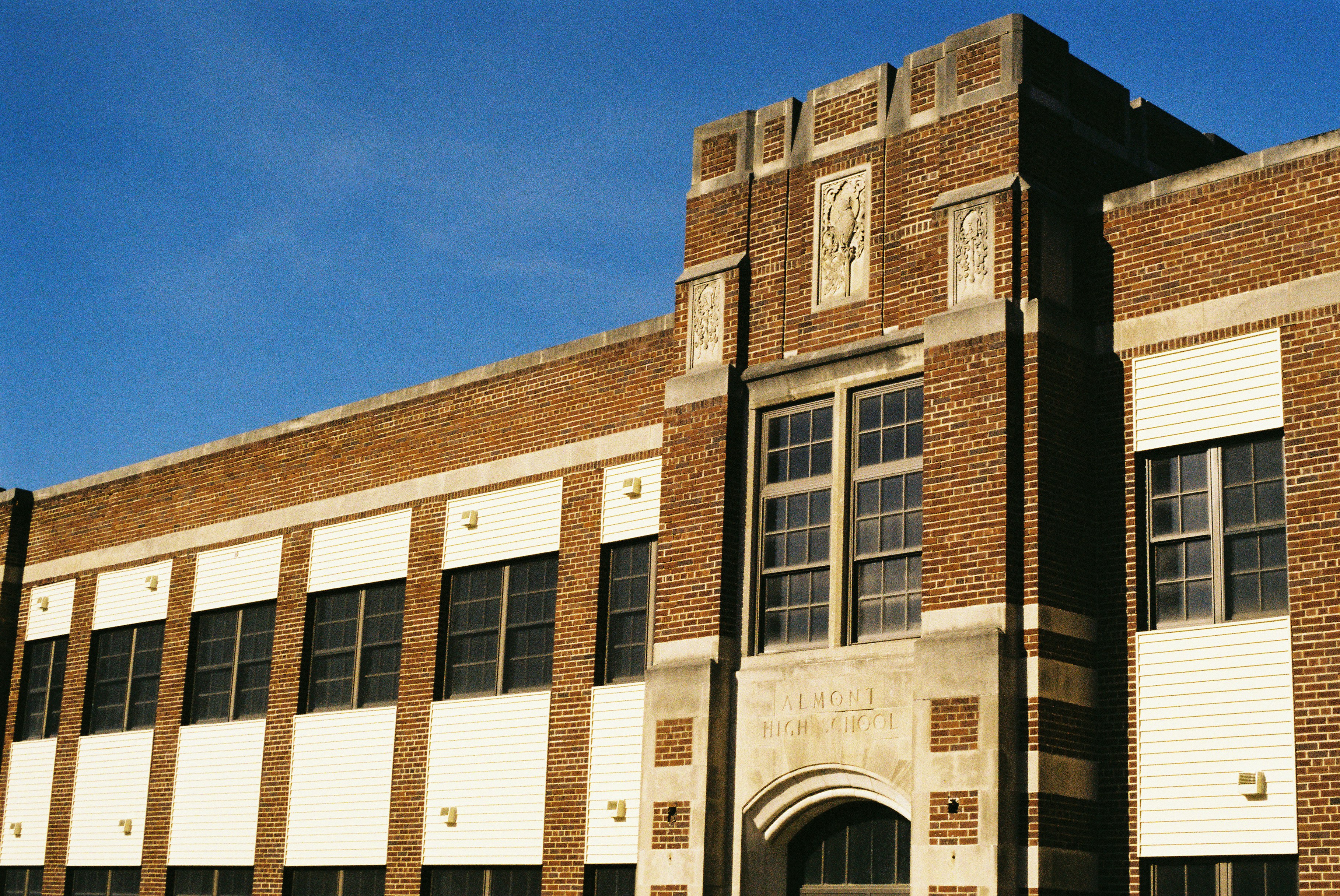 a tall brick building with a clock on it's side