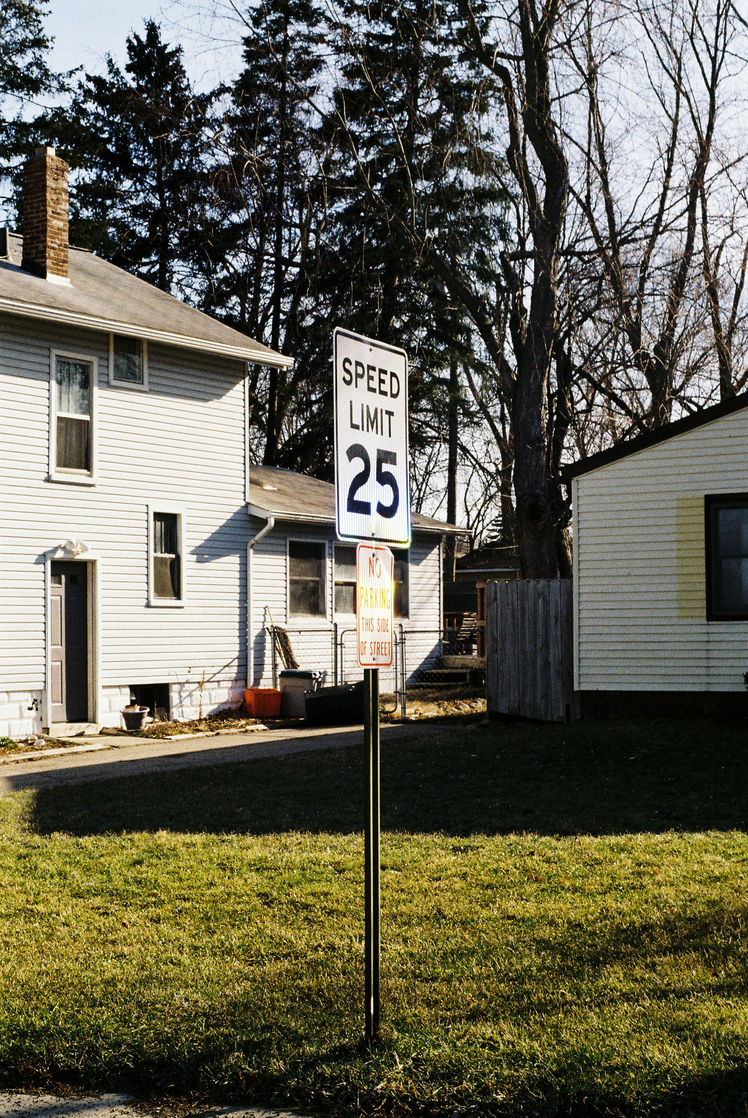 a speed limit sign in front of a house