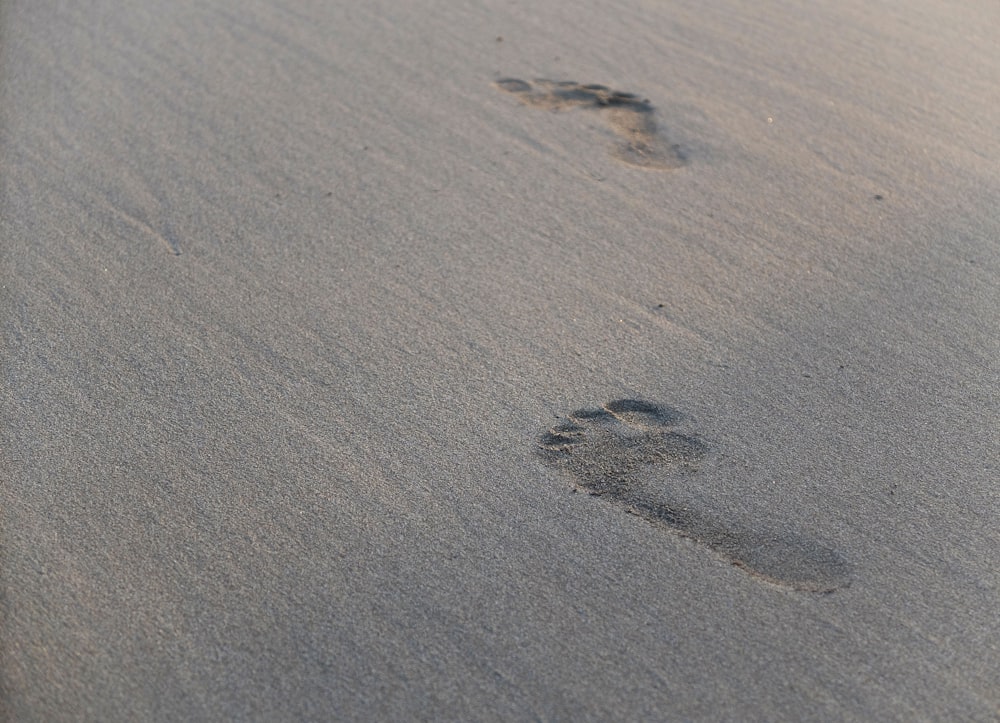 two footprints in the sand of a beach