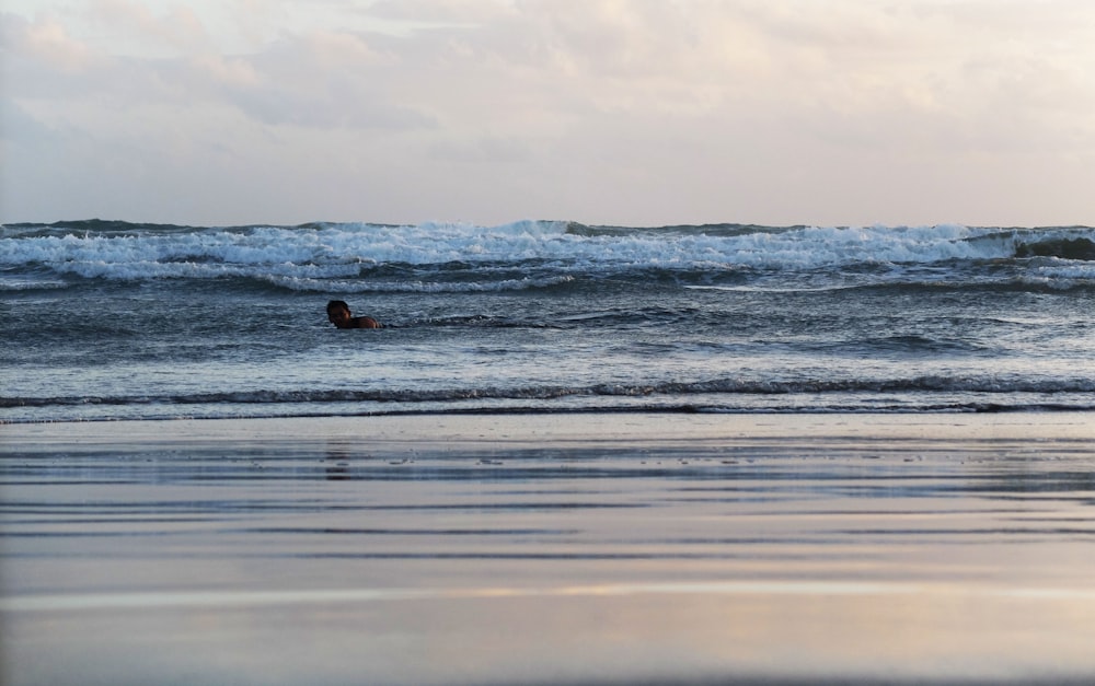 a person laying on a surfboard in the ocean