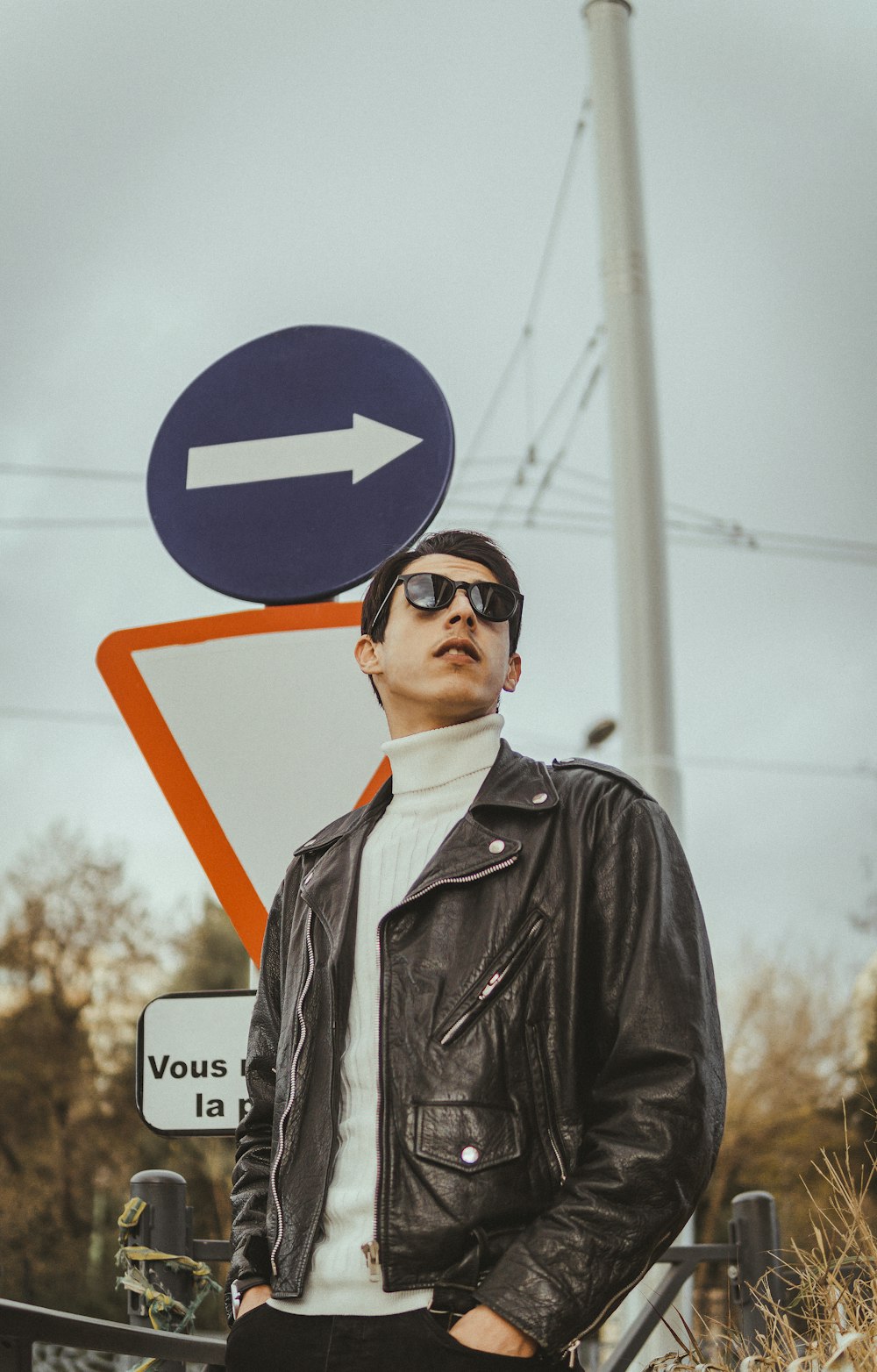 a man standing next to a street sign