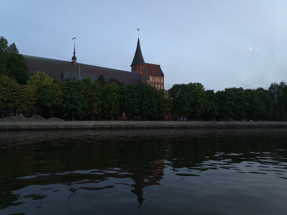 un grande edificio seduto accanto a uno specchio d'acqua