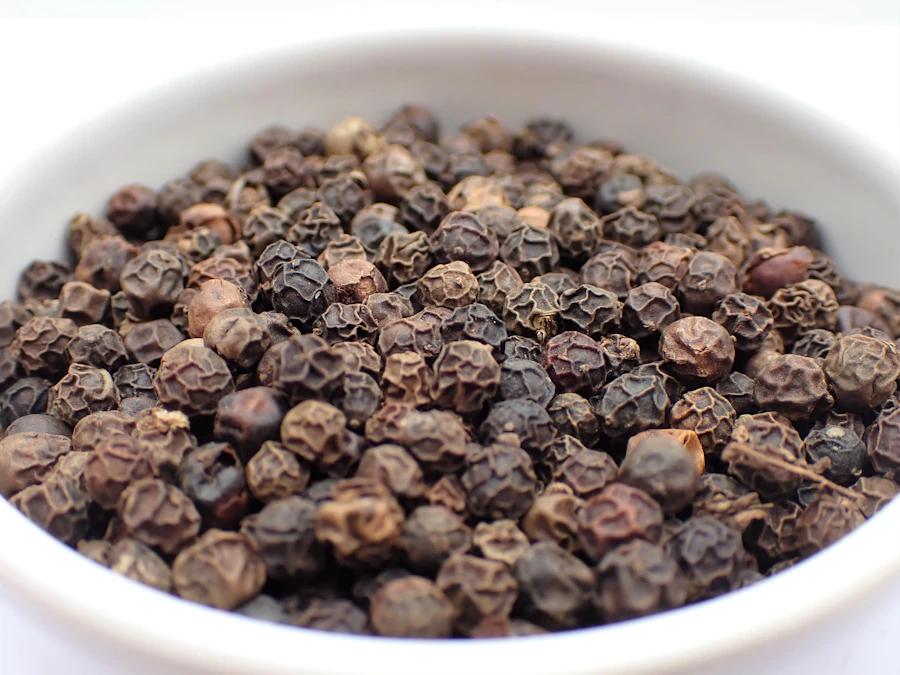 Bowl of graded whole black peppercorns ready for export packing