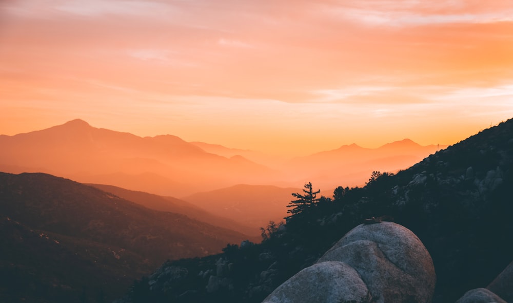 a person standing on top of a mountain at sunset