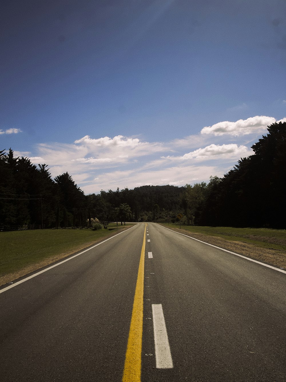 an empty road with a yellow line in the middle of it