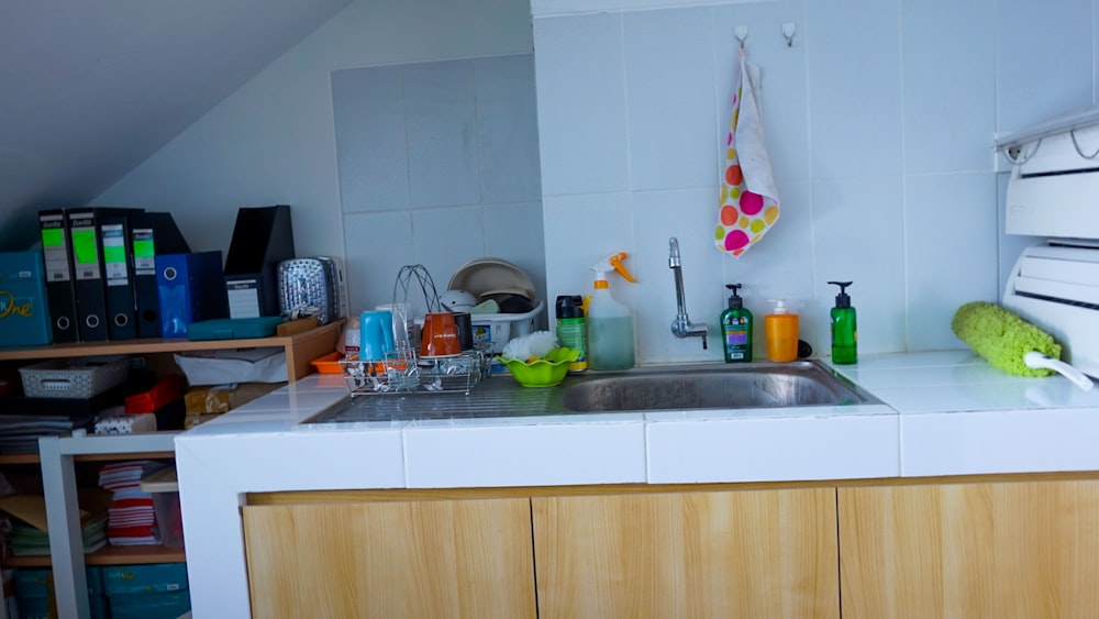 a kitchen with a sink and a lot of clutter on the counter
