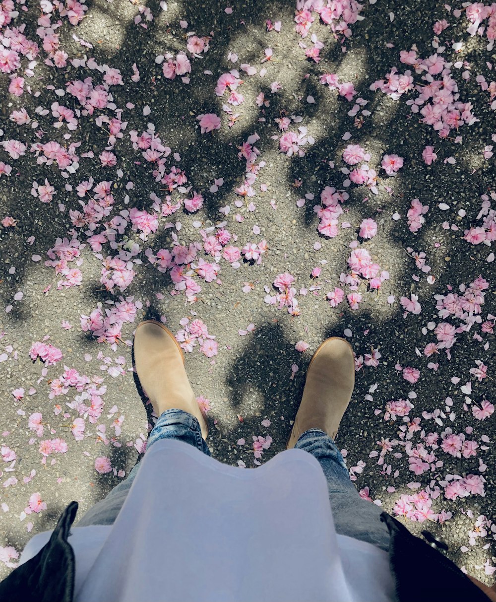 a person standing in front of pink flowers