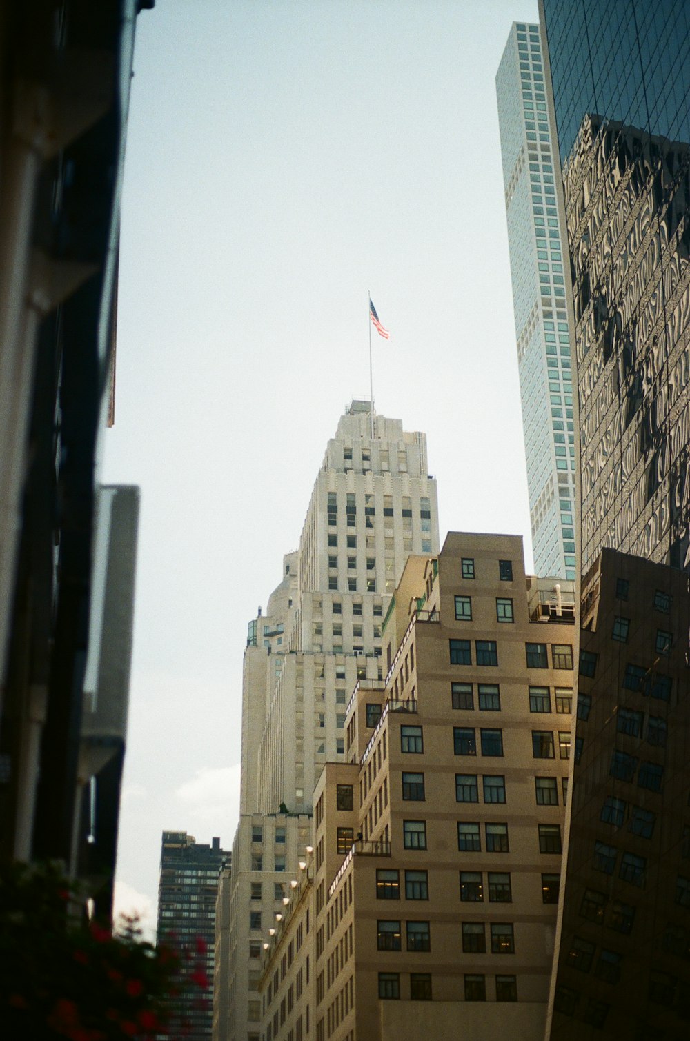 a city street with tall buildings and a flag on a pole