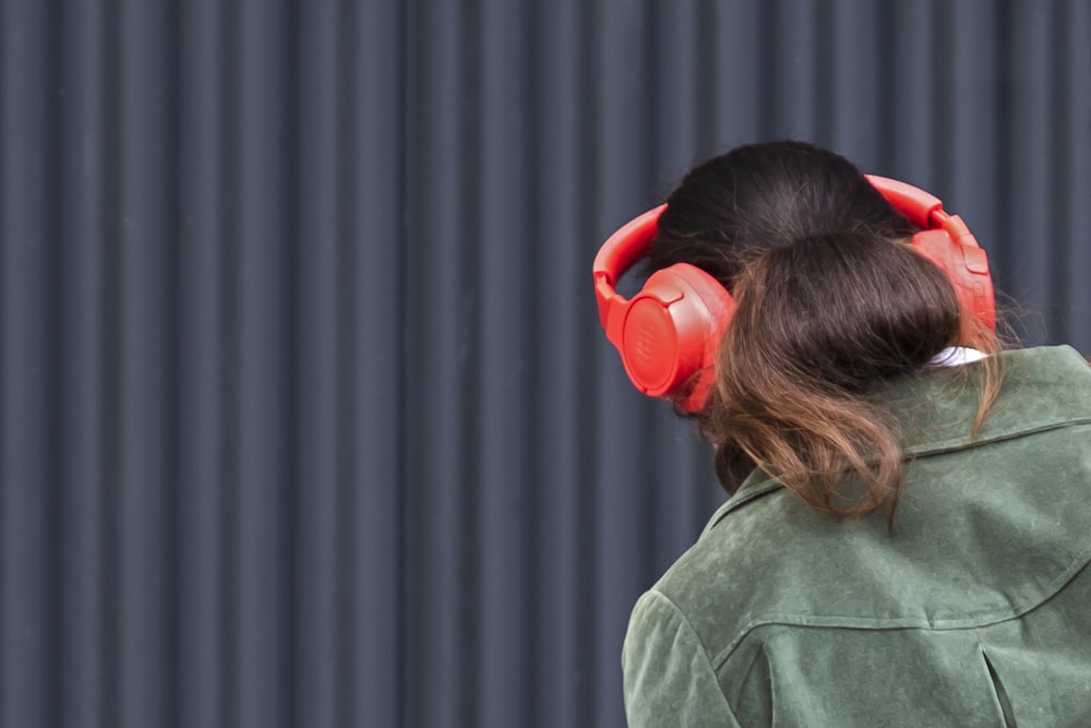 a woman wearing red headphones and a green jacket