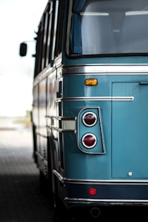 a blue bus parked on the side of the road