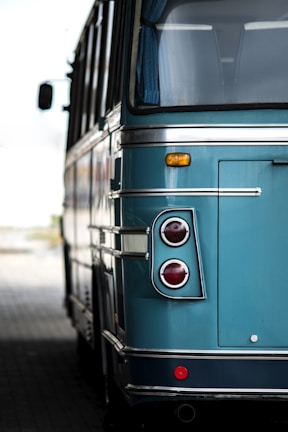 a blue bus parked on the side of the road