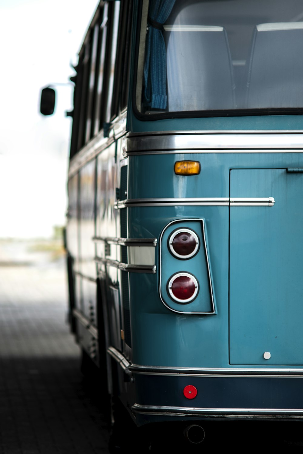 a blue bus parked on the side of the road