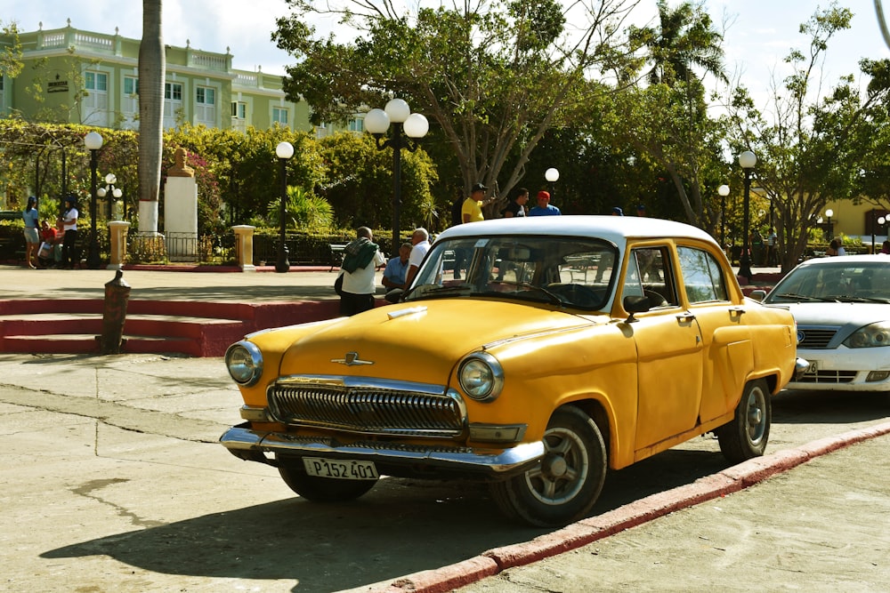 a yellow and white car parked on the side of the road