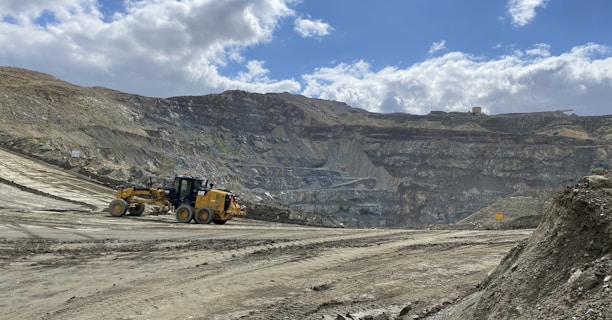 a bulldozer is driving down a dirt road