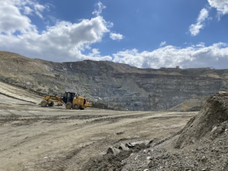 a bulldozer is driving down a dirt road