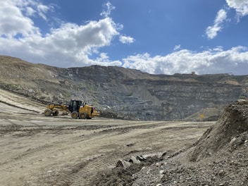 a bulldozer is driving down a dirt road