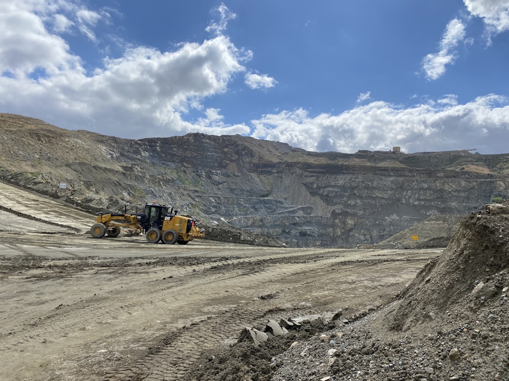 a bulldozer is driving down a dirt road