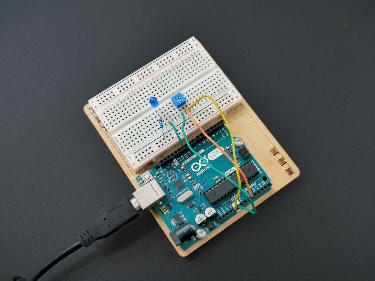 Una placa electrónica con herramientas de soldadura sobre una mesa de trabajo.