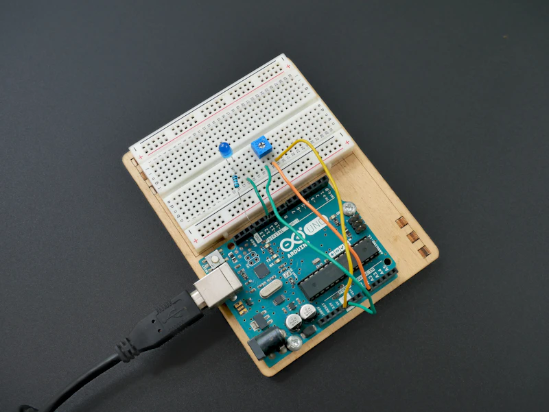 Una placa electrónica con herramientas de soldadura sobre una mesa de trabajo.