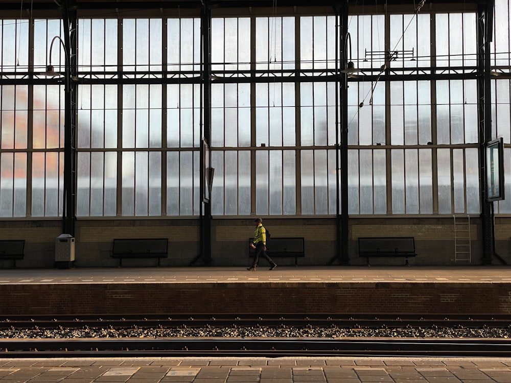 a train station with a person walking on the platform