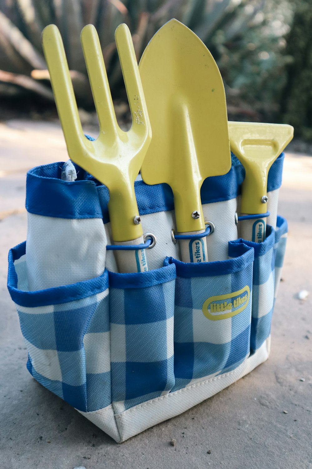 a blue and white checkered bag with yellow utensils in it