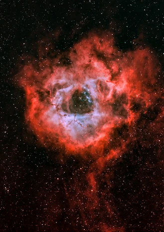 Close-up of a protostar surrounded by dense clouds of gas and dust, hinting at stellar formation.