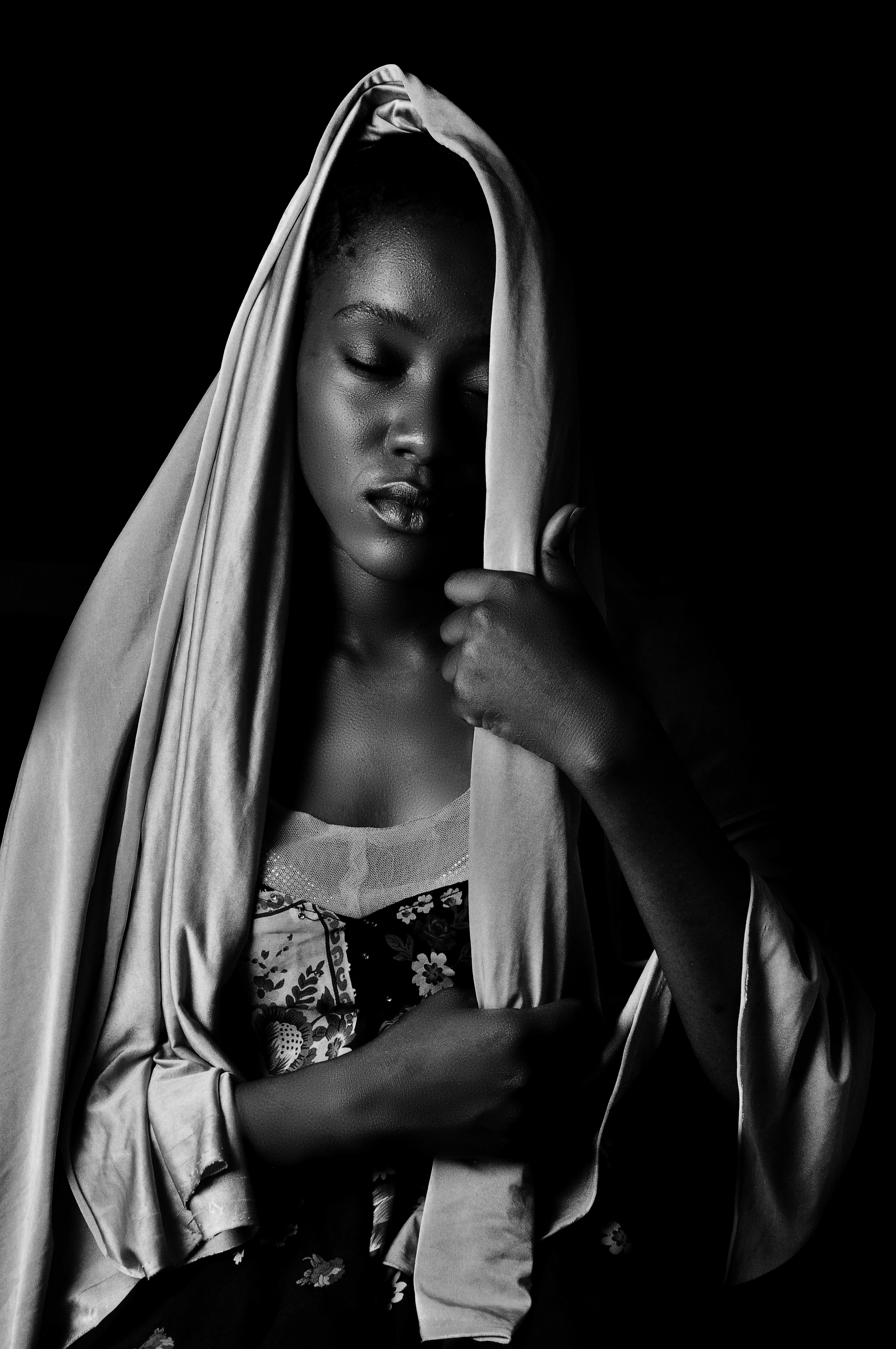 a black and white photo of a woman wrapped in a blanket