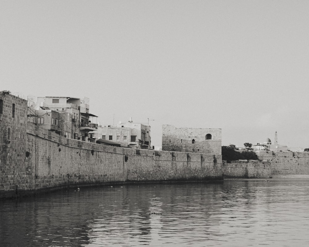 a black and white photo of a city by the water