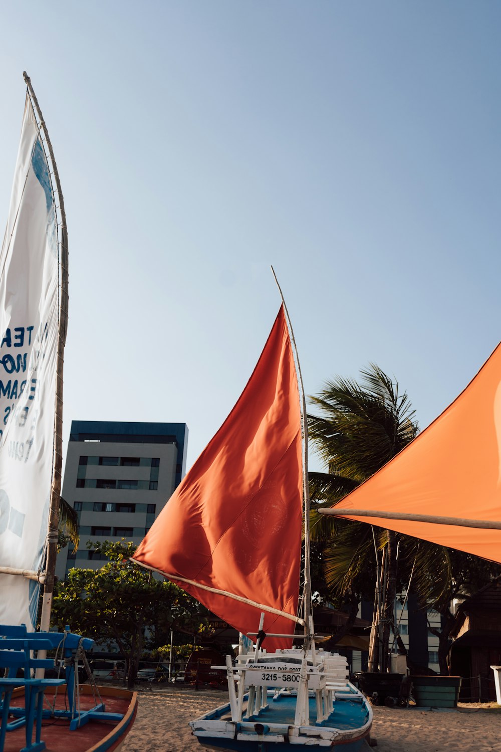 a sailboat on the beach with a flag on top of it