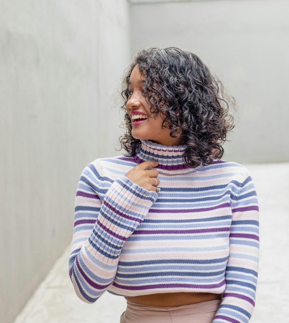 a woman with curly hair wearing a striped sweater