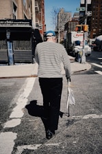 a woman walking down a street holding a bag