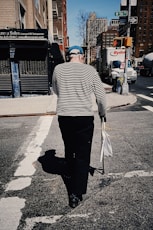 a woman walking down a street holding a bag